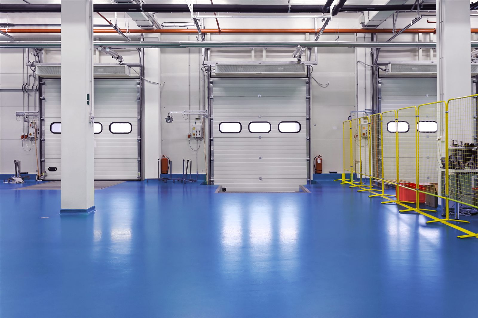 Cortina de ar industrial instalada sobre portas de doca em câmara refrigerada